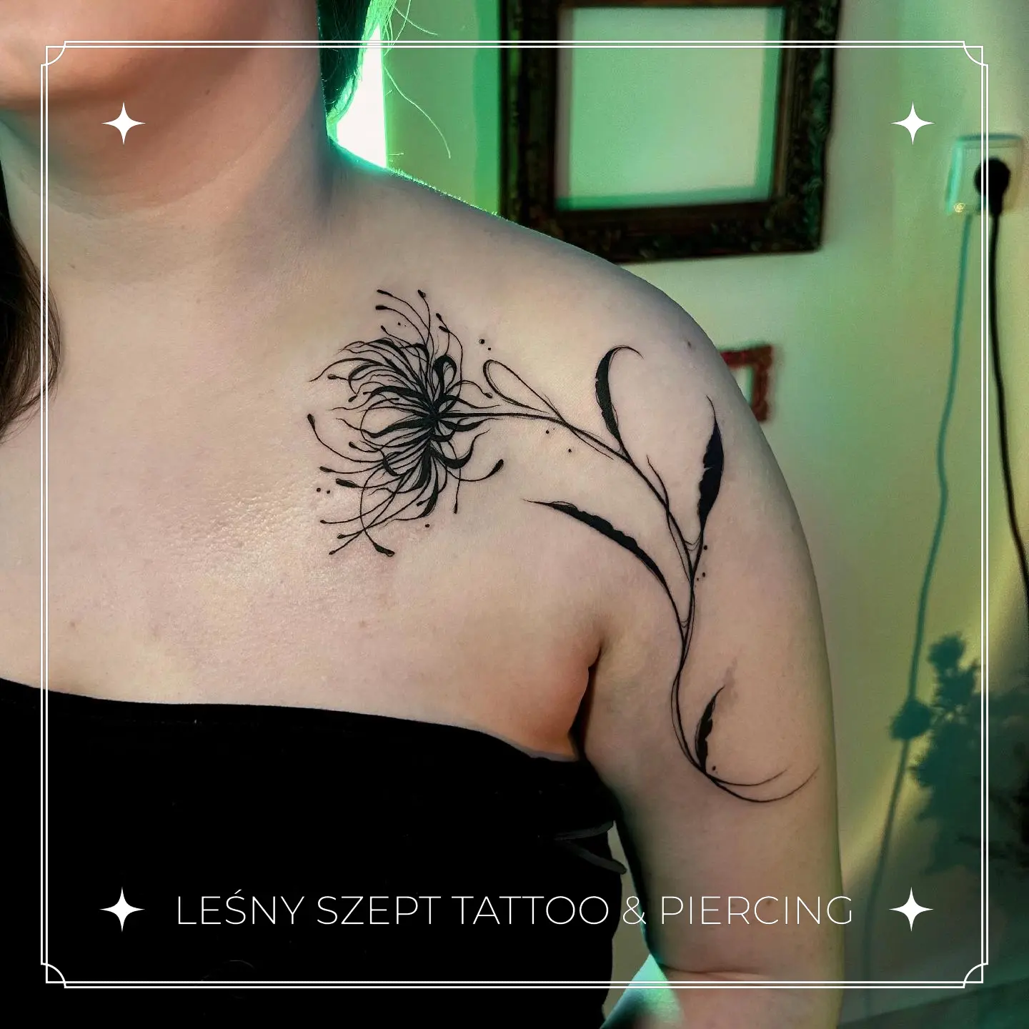 Tatuaż kwiatu spider lily w stylu czarnego tuszu, umieszczony na barku i obojczyku