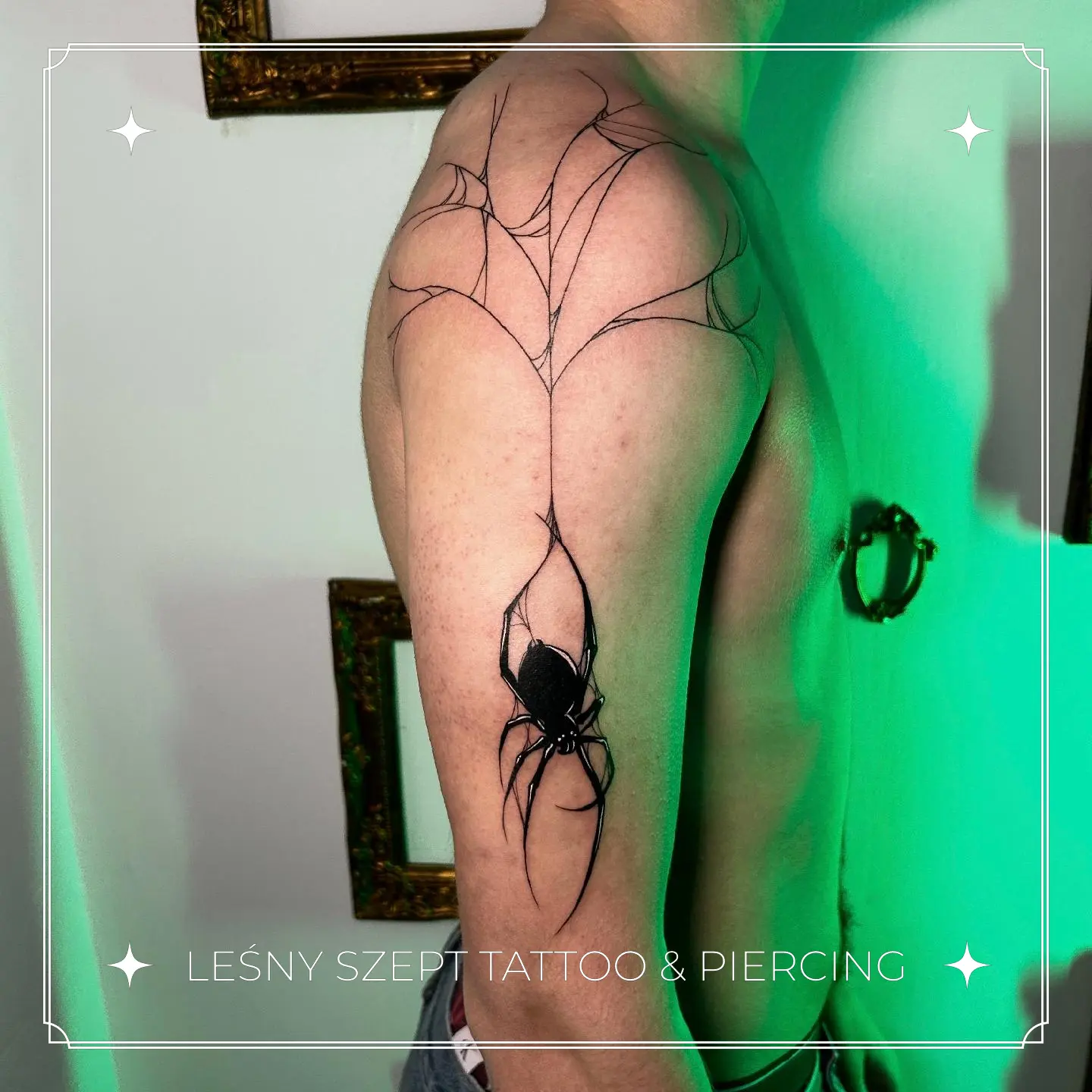 Tatuaż przedstawiający czarnego pająka z abstrakcyjną siecią rozciągającą się na ramię i bark