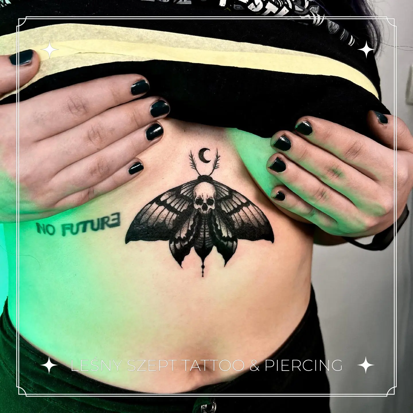 Czarny tatuaż ćmy śmierci z czaszką i półksiężycem, na brzuchu