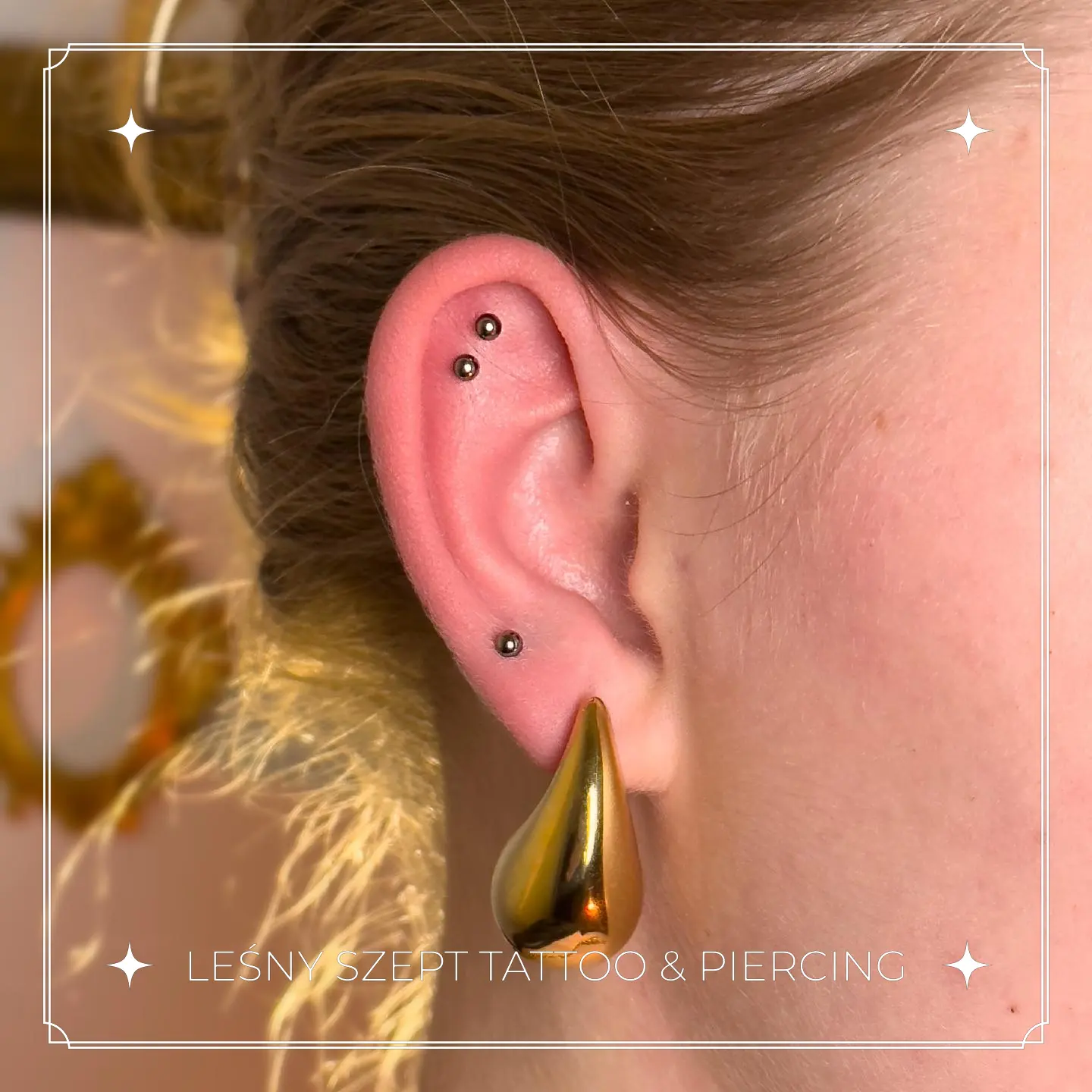 Kolczyki w uchu – dwa przekłucia helixa i złoty tunel w płatku ucha
