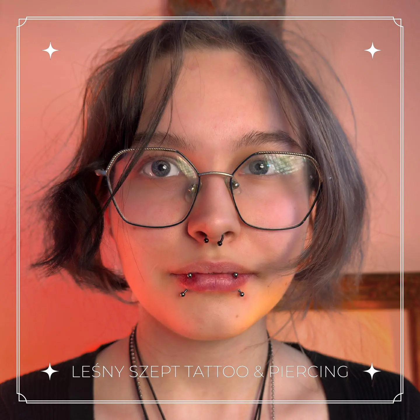 Zestaw kolczyków w twarzy – septum, pionowy labret i spider bite na ustach