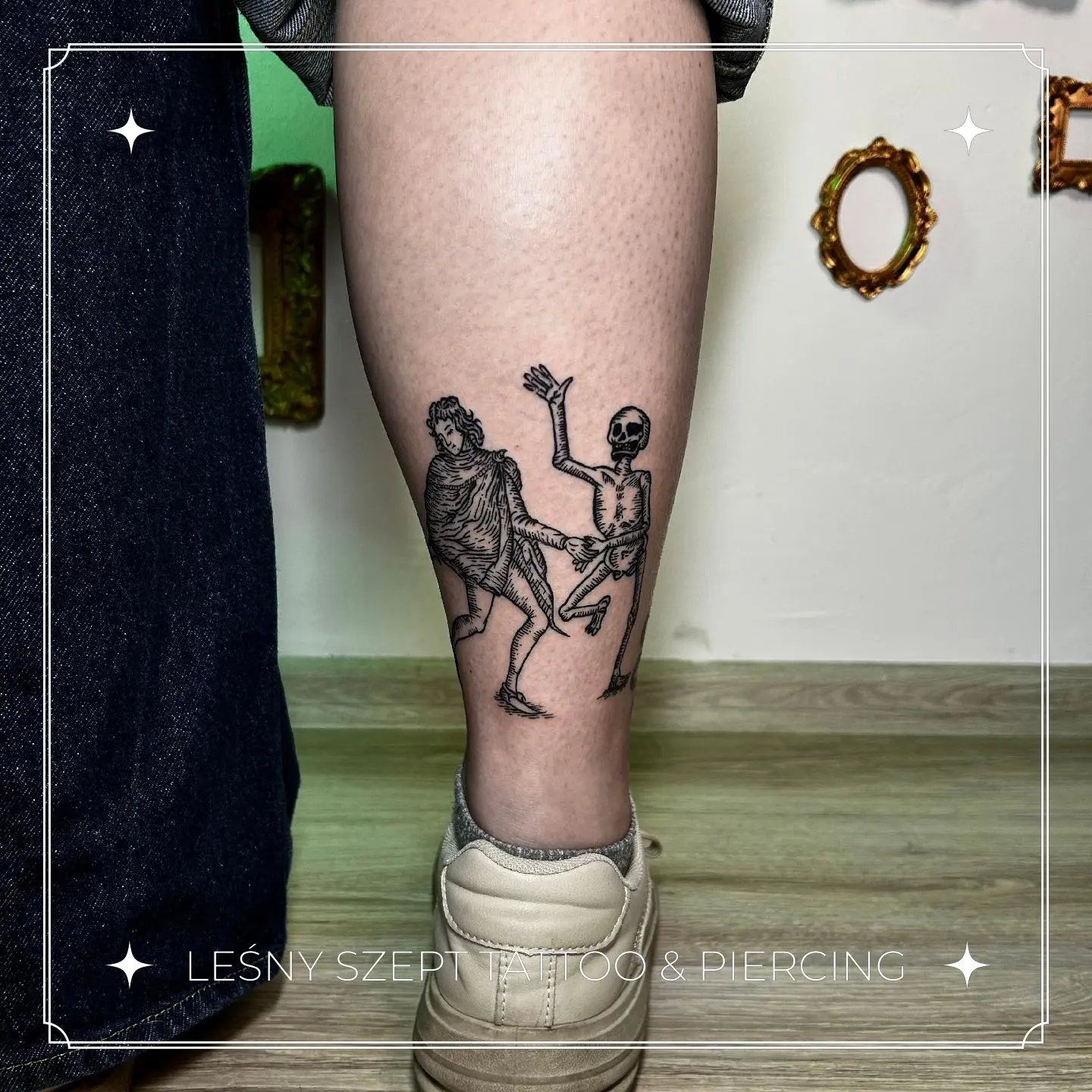 Tatuaż w stylu średniowiecznym przedstawiający taniec śmierci ze szkieletem, na łydce