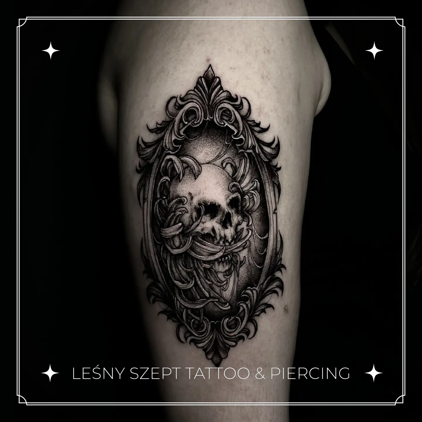 Tatuaż czarno-szary przedstawiający czaszkę zamkniętą w ornamentalnej ramie w stylu blackwork