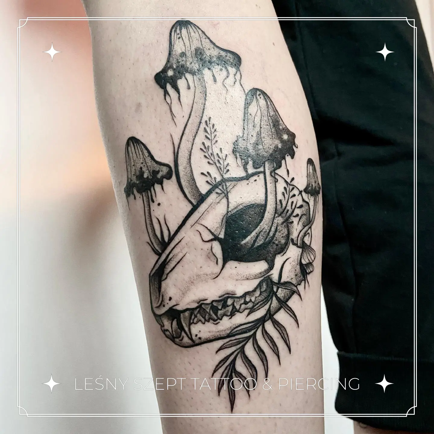 Tatuaż zwierzęcej czaszki z wyrastającymi grzybami i roślinami, na udzie