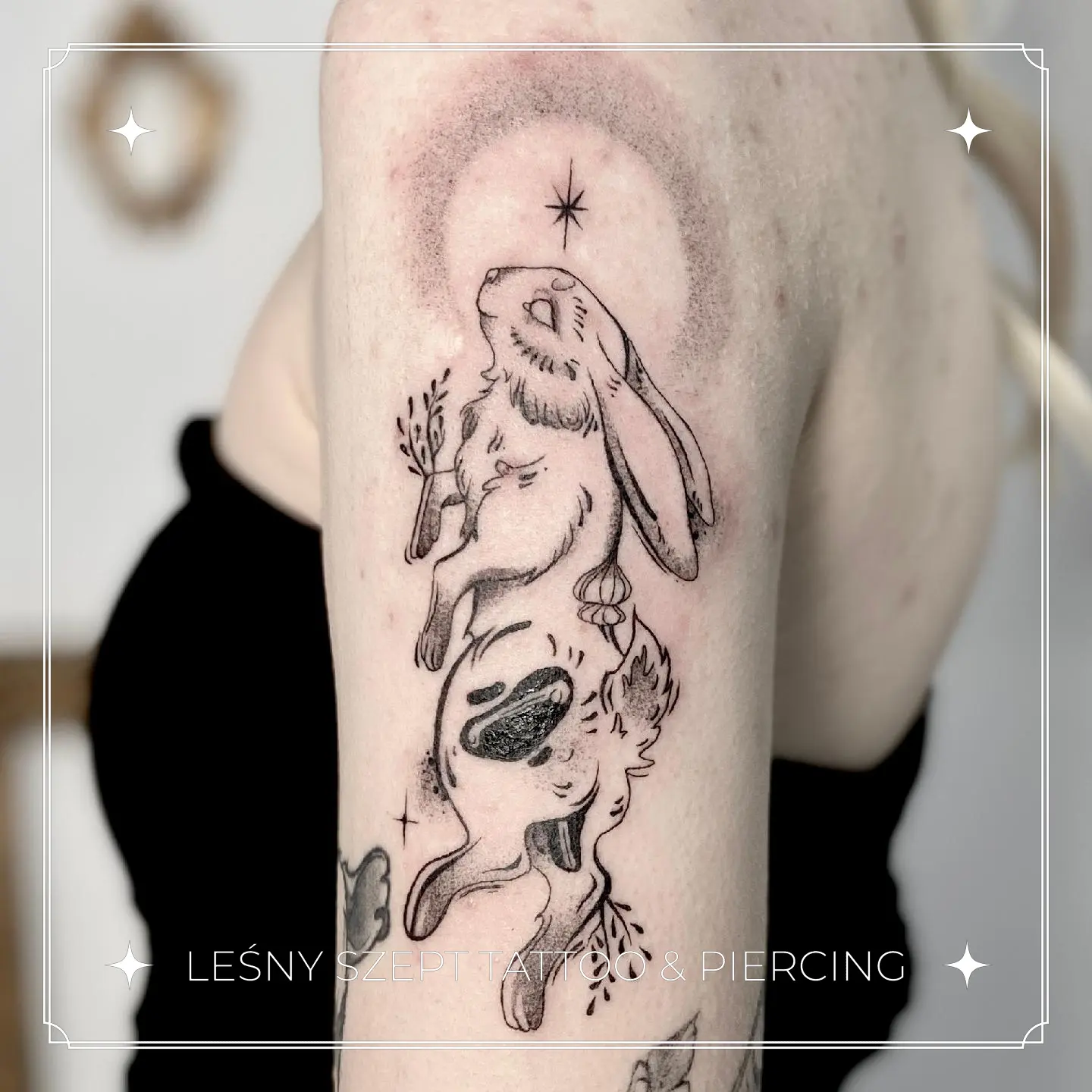 Ilustracyjny tatuaż dwóch królików z ziołami i magiczną aurą, na ramieniu