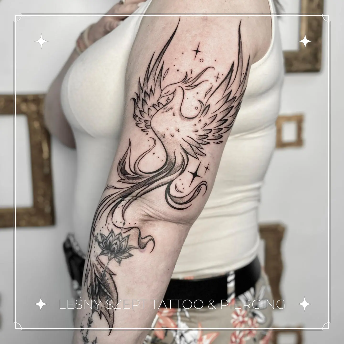 Tatuaż feniksa ze wzniesionymi skrzydłami, gwiazdkami i kwiatem lotosu
