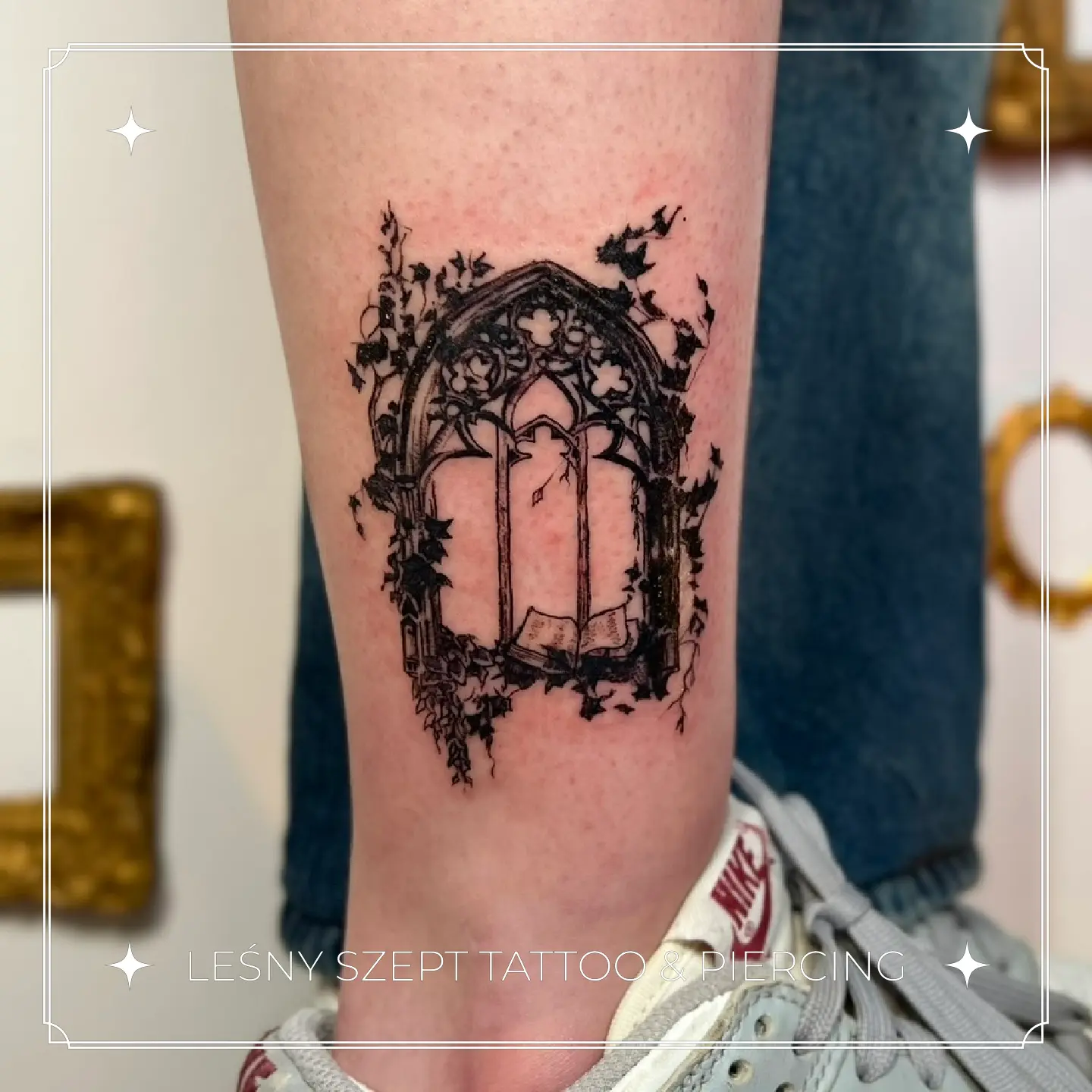 Tatuaż gotyckiego okna porośniętego bluszczem na łydce