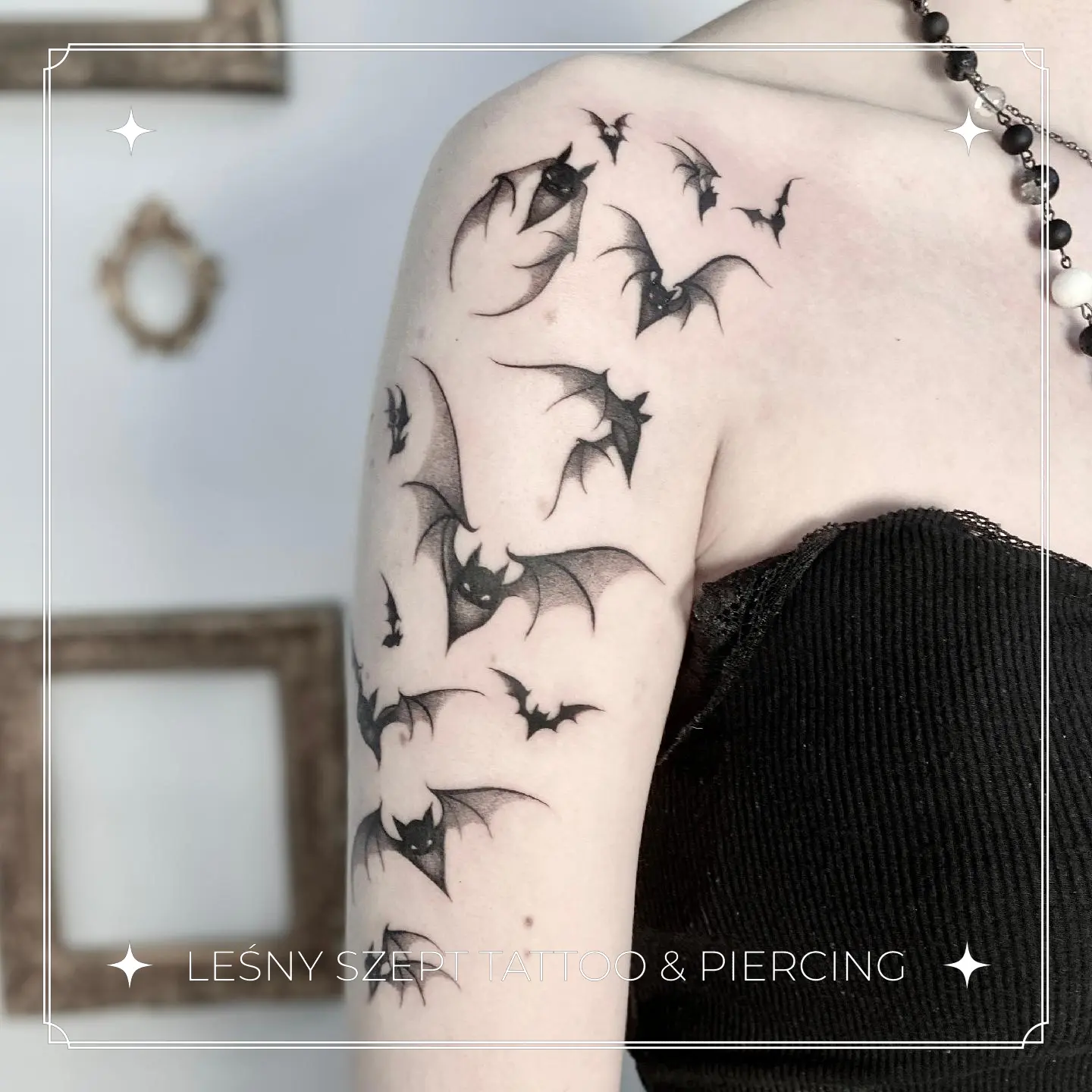 Tatuaż grupy latających nietoperzy w stylu blackwork, na ramieniu