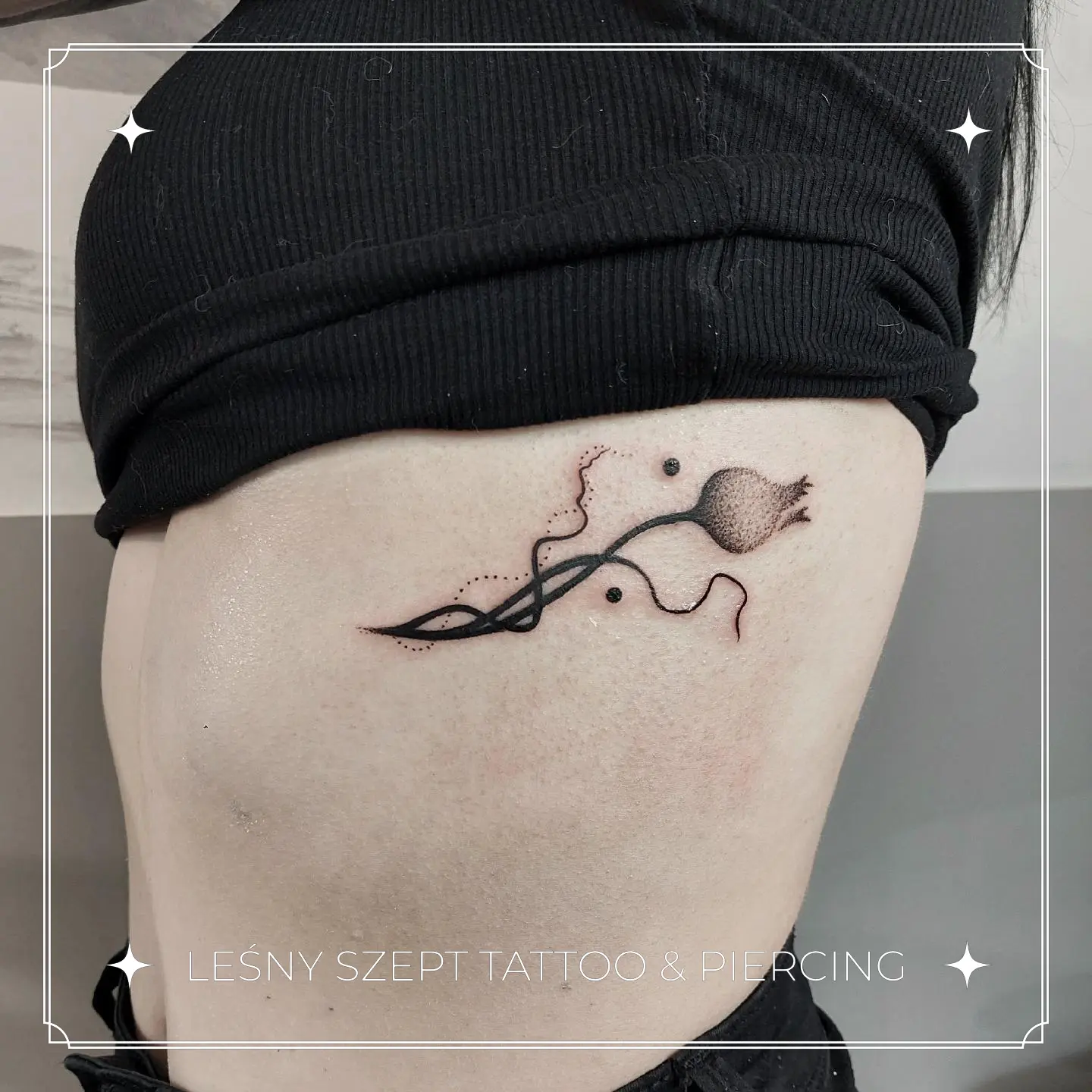 Tatuaż pojedynczej makówki z abstrakcyjnymi kształtami na żebrach