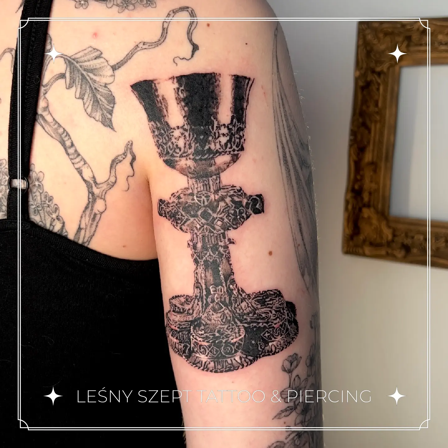 Tatuaż ozdobnego pucharu w stylu blackwork na ramieniu