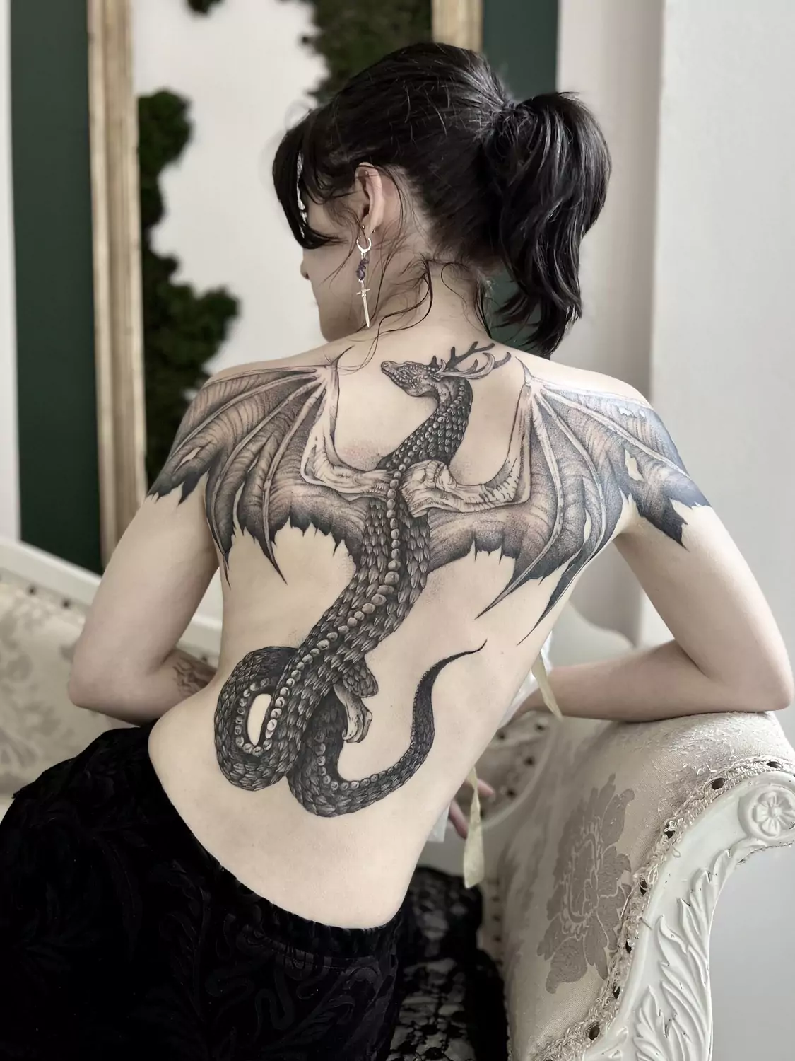 Tatuaż smoka z porożem rozciągający się przez całe plecy, wykonany czarnym tuszem