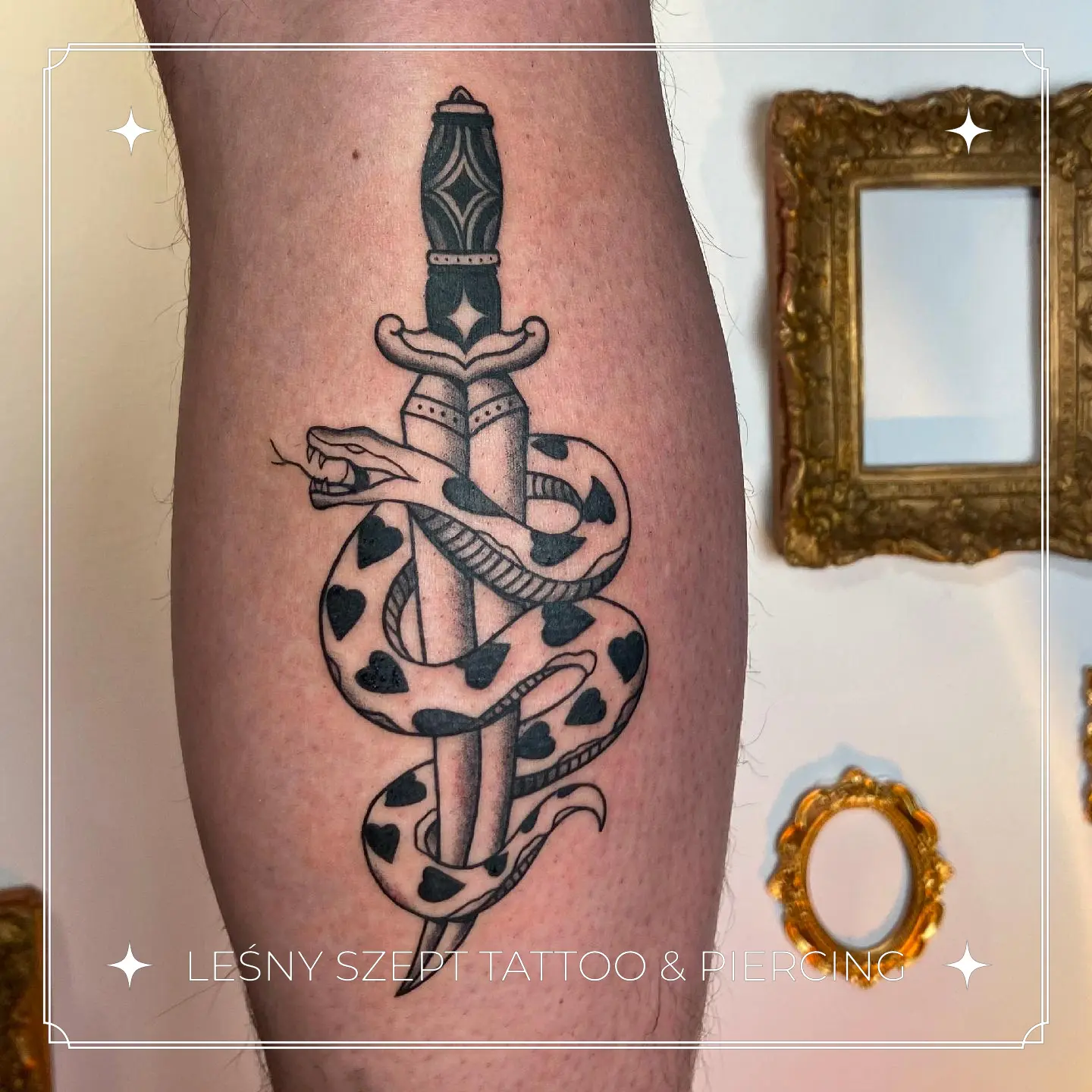 Tatuaż sztyletu oplecionego przez węża z motywami serc na łydce