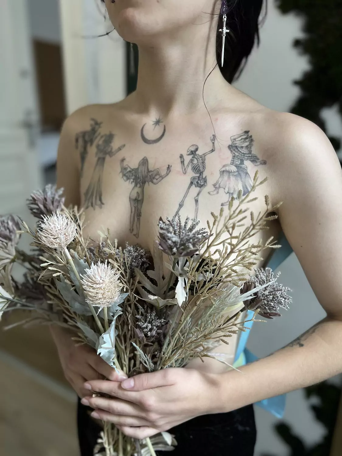 Tatuaż tańczących postaci wiedźm i szkieletów z półksiężycem, na klatce piersiowej