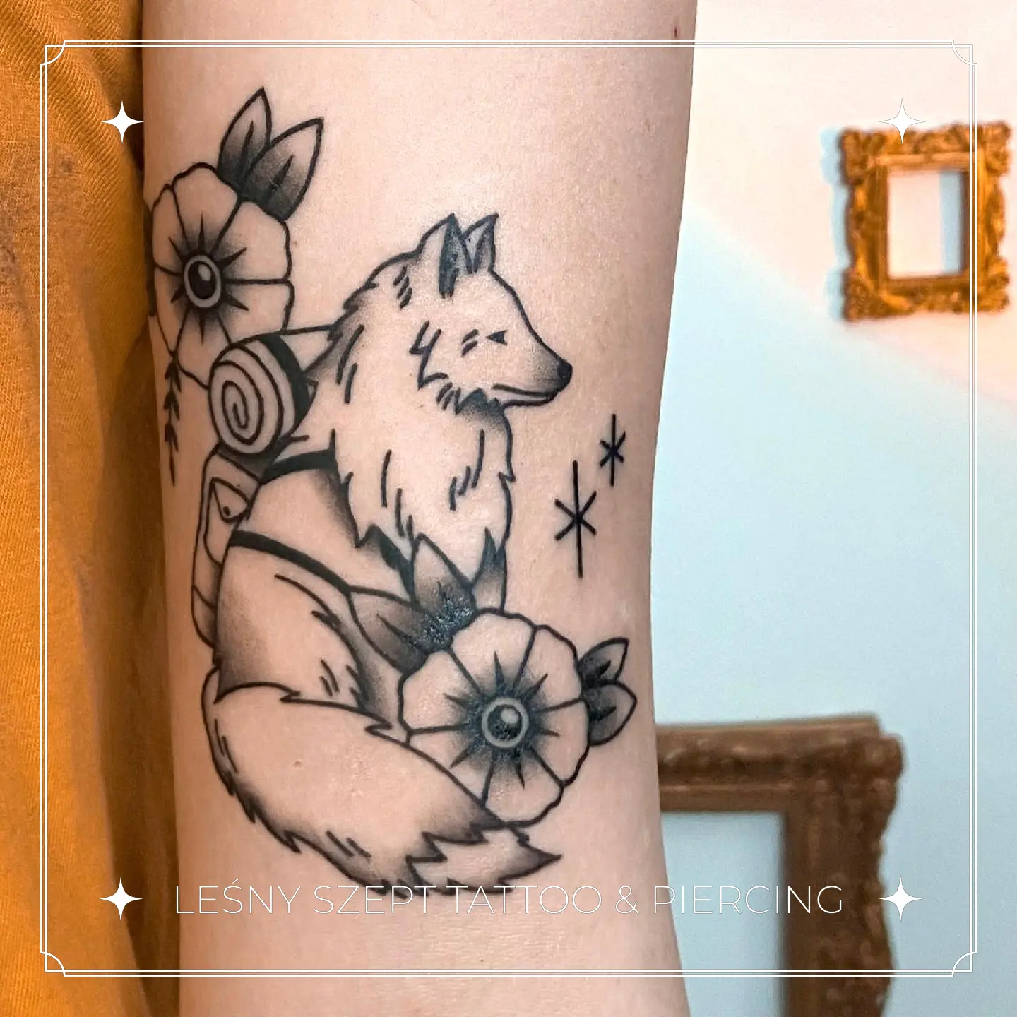 Tatuaż wilka z plecakiem i kwiatami na ramieniu